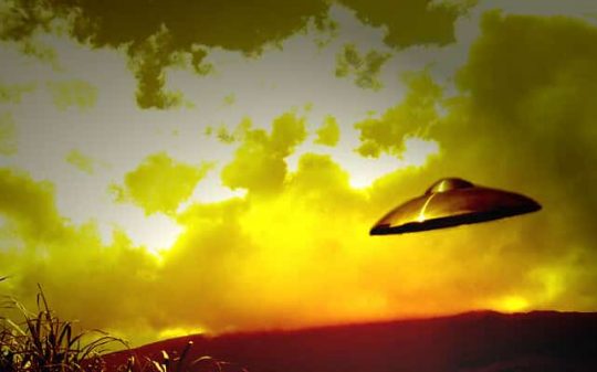 ufo flying near clouds