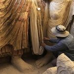 statues examined by archaeologist