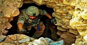 us soldier climbing out of cave